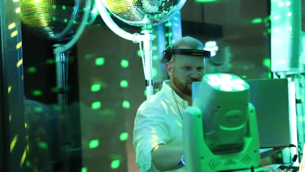 Standbild aus dem Showreel: James Kuma hinter der weißen Booth im Abendlicht
